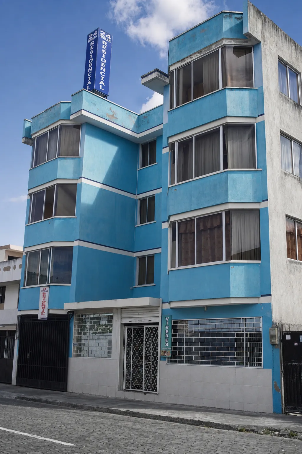 Fachada completa de la residencial azul vista desde la calle
