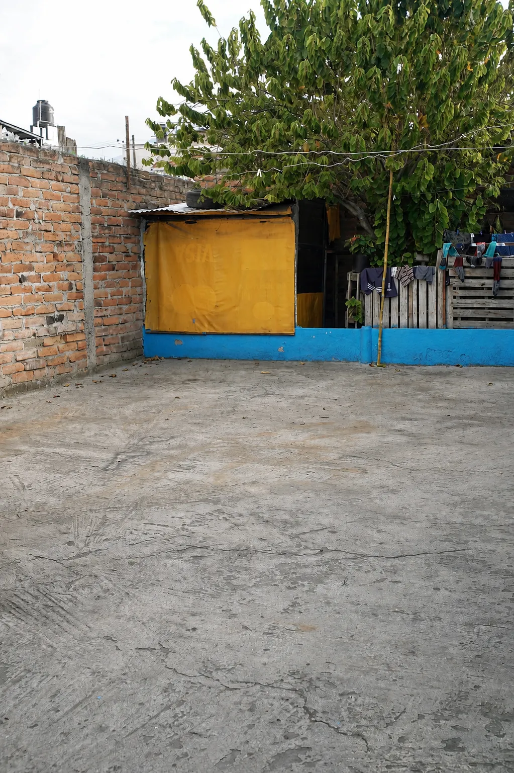 Patio de parqueadero con piso de cemento y espacio libre para varios vehículos